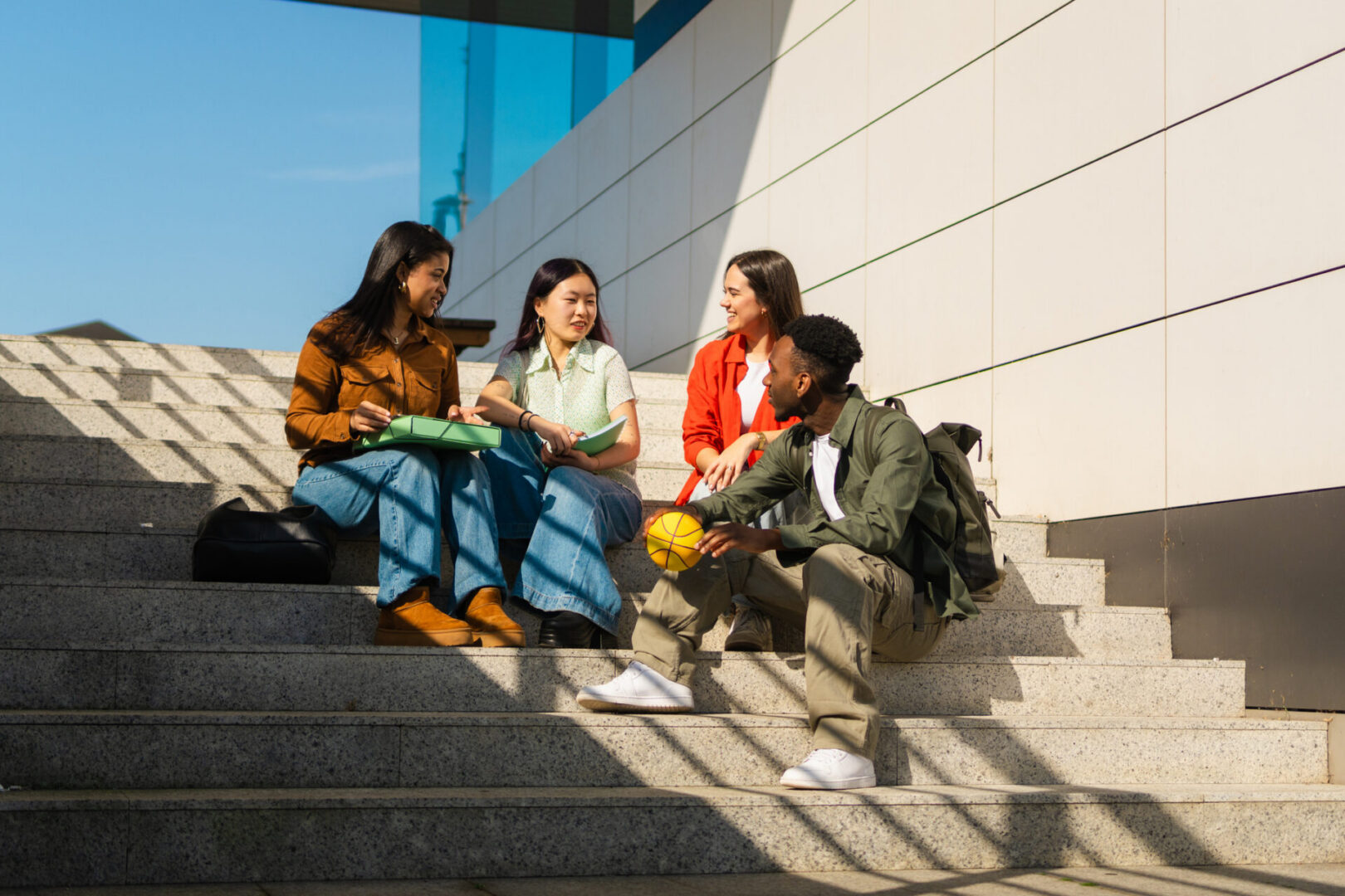 Group of students sitting on steps with basketball